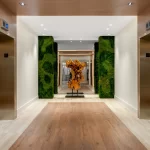Elevator lobby at the Rony Palace featuring accent lighting live moss wall and abstract wood sculpture renovated by Capital Contractor Services